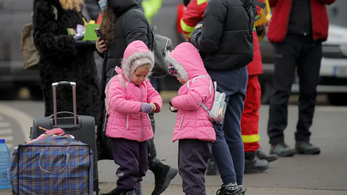 Ukrainische Kinder öffnen an der rumänisch-ukrainischen Grenze Süßigkeiten, die sie von Freiwilligen erhalten haben, nachdem sie vor dem Konflikt in der benachbarten Ukraine geflohen sind. Wegen des russischen Angriffs auf die Ukraine sind nach Angaben des UN-Flüchtlingshilfswerks (UNHCR) etwa 368 000 Menschen auf der Flucht. +++ dpa-Bildfunk +++