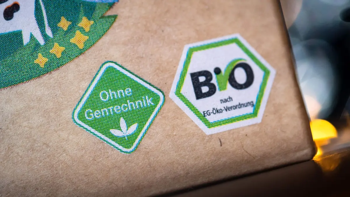 Das Logo „Ohne Gentechnik“ und das Bio–Siegel sind auf einer Lebensmittelverpackung. (zu dpa: „Bauernverband: Bio–Markt konsolidiert sich wieder»)