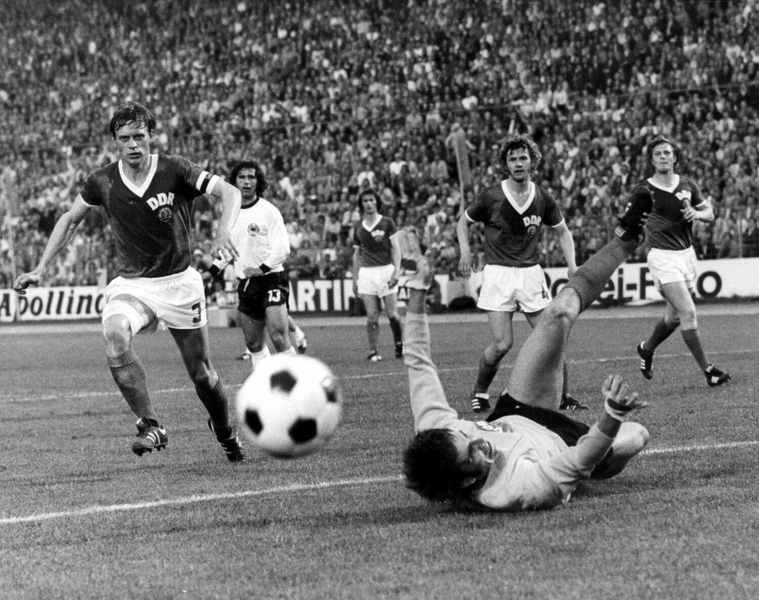 Fußball-WM 1974, BRD - DDR 0:1: Jürgen Croy (vorn) liegt nach einer Parade am Boden, v.l. laufen Kapitän Bernd Bransch (DDR), Gerhard Müller (BRD) und drei weitere DDR-Spieler heran. Die DDR gewann im Hamburger Volksparkstadion das Finalrundenspiel der Fußball-WM gegen die Elf der Bundesrepublik Deutschland mit 1:0.