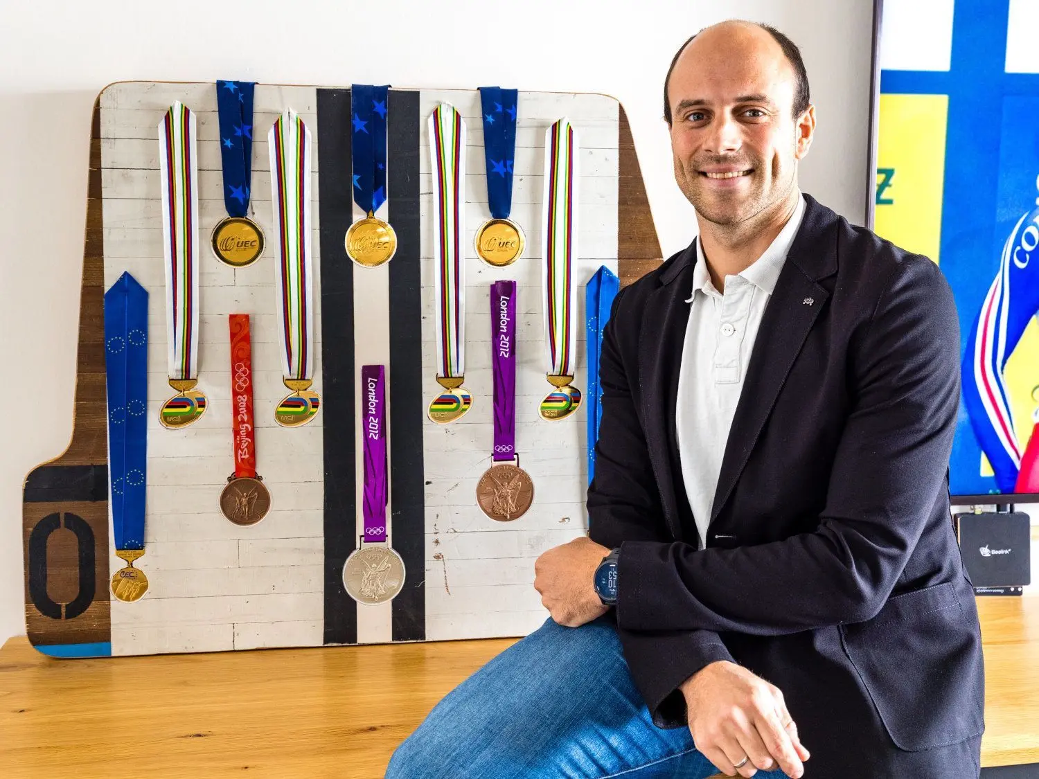 13.09.2021, Brandenburg, Cottbus: Maximilian Levy sitzt vor einer Sammlung seiner wichtigsten Medaillen.Maximilian Levy gibt das Ende seiner Karriere als Bahnradsprinter nach vier Olympischen Spielen und zehn WM-Medaillen bekannt. Ab 2022 ist er Junioren-Bundestrainer.Foto: Frank Hammerschmidt
