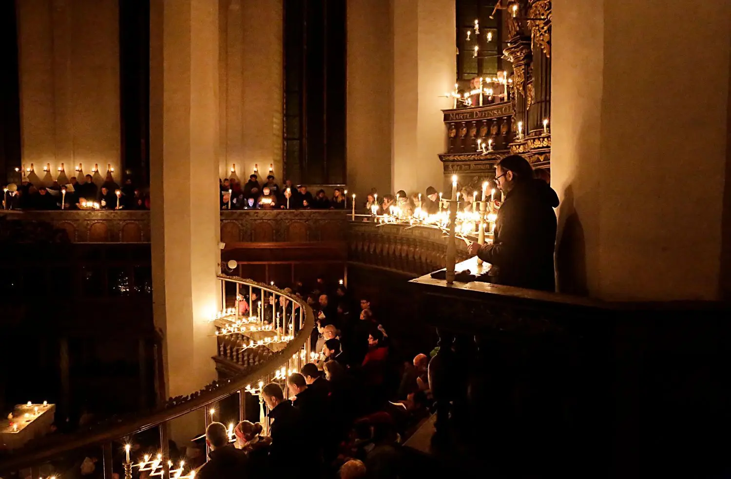 Rund tausend Kerzen erleuchten die große Hallenkirche St. Nikolai in Luckau zur Christmette. Während des Quempas-Singens werden auch auf den Etagen der Orgelempore zahlreiche Lichterscheren von den Besuchern und Sängern bewegt.