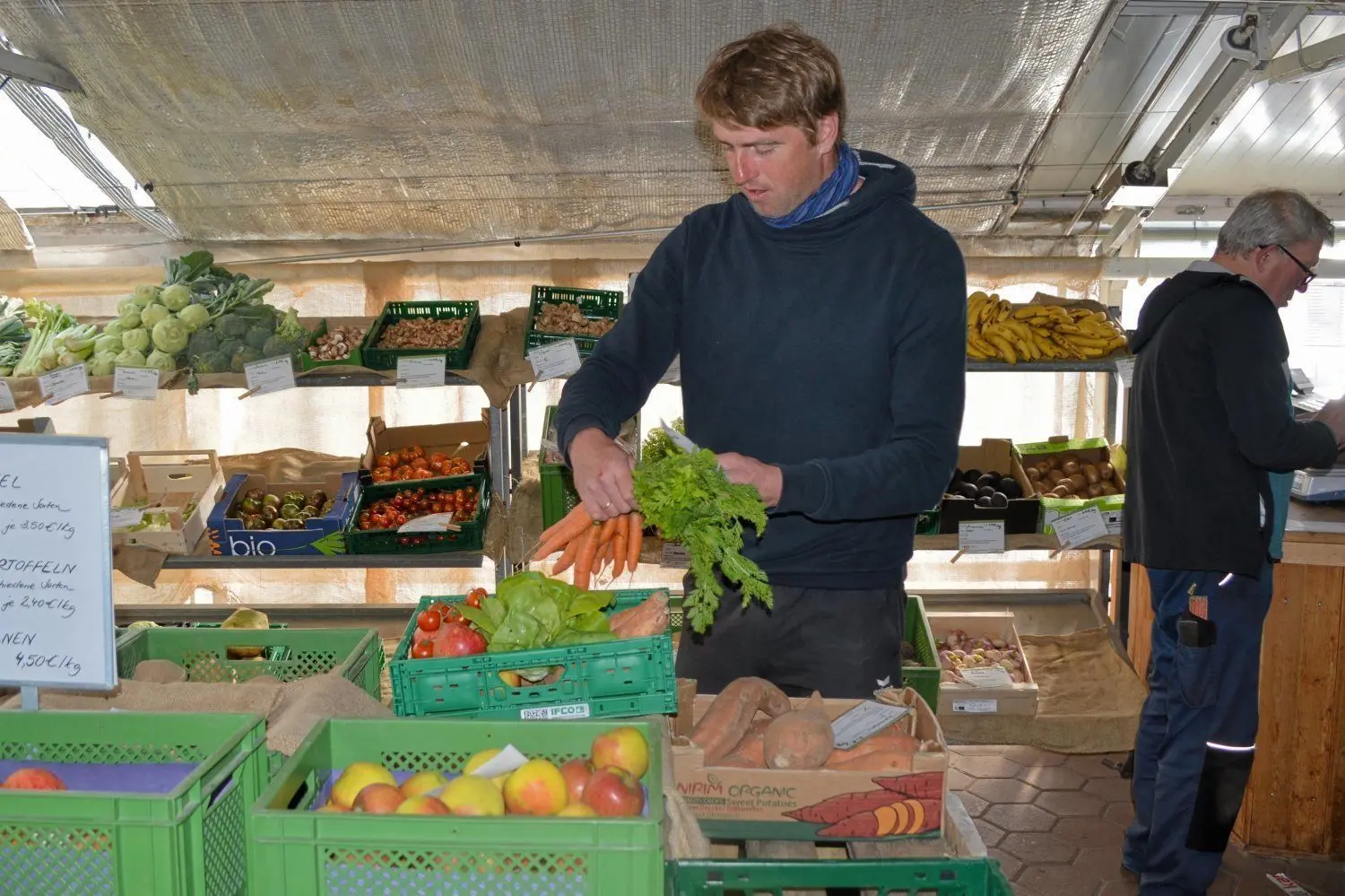 Christian Kochan packt eine Gemüsekiste auf dem Wochenmarkt.