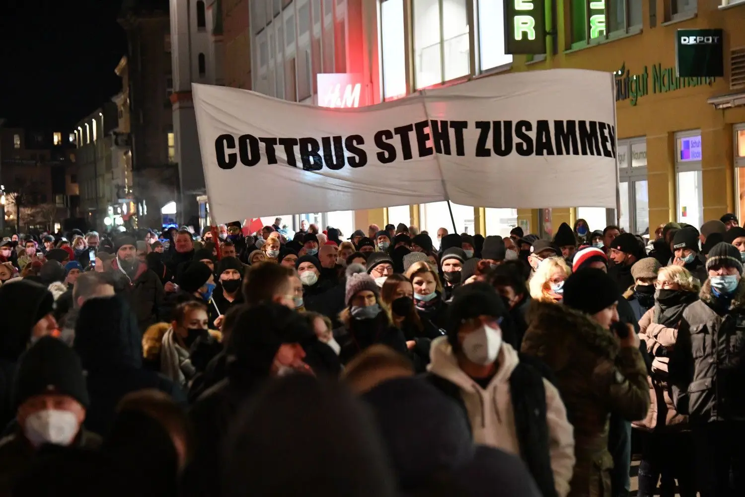 Hinter dem Transparent mit der Aufschrift „Cottbus steht zusammen“ versammelt sich tatsächlich nur eine Minderheit der Cottbuser. Die meisten Bürger akzeptieren die Corona-Schutzregeln und bleiben daheim.