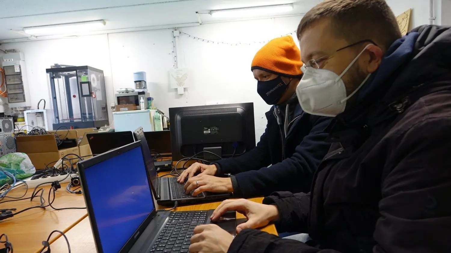 Christian Hanschke (vorn) und Benjamin Andriske löschen die Daten auf den alten Rechnern und laden Linux als neues Betriebssystem sowie freie Office-Programme hoch. Mehr als 30 Geräte wurden innerhalb der ersten Woche gesponsert.