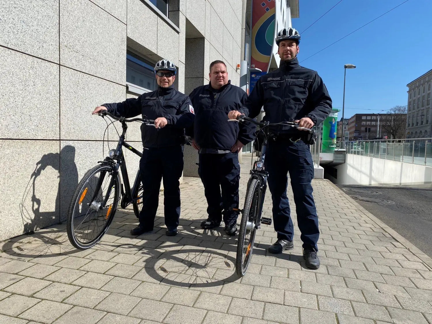 Jens Kirsch ((l.) und Tony Welzel (r) gehen ab Donnerstag auch mit dem Fahrrad auf Streife. Ihr Chef Ordnungsamtsleiter Manuel Helbig (Mitte) freut sich über die flotte Unterstützung. Er sagt: „Damit sind die Kollegen schneller an den Einsatzorten. Sie werden auch entlang der Spree und in den Parks patrouillieren.“