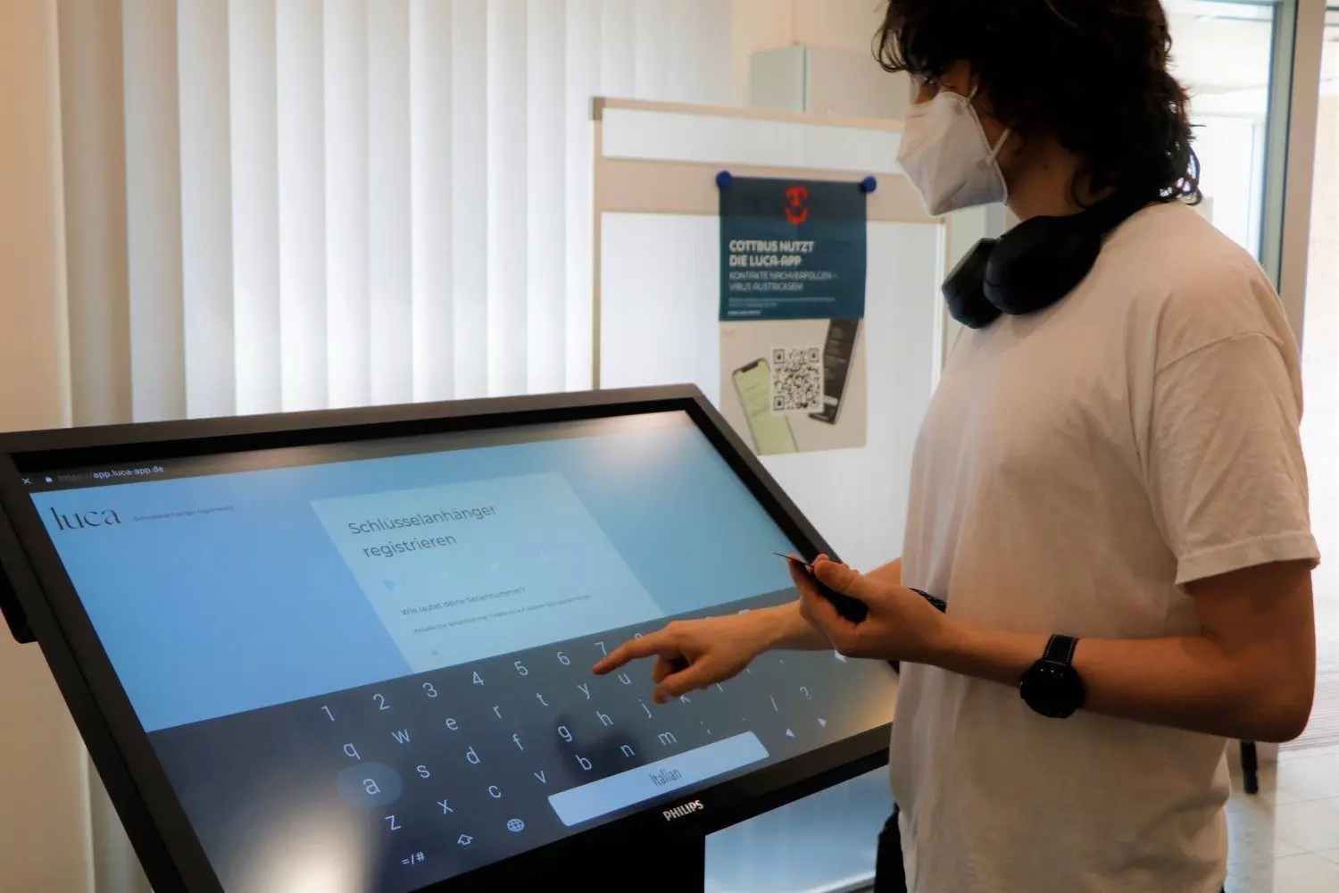 Mitarbeiter des Cottbuser Sicherheitszentrums helfen bei der Registrierung der Luca-Schlüsselanhänger an einem neuen Terminal.