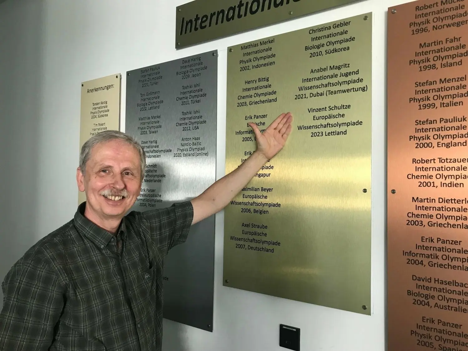 Frank Ristau, Schulleiter des Max-Steenbeck-Gymnasiums in Cottbus, zeigt auf die Ehrentafel neben der Aula. In den vier Jahren, in denen er Schulleiter war, errangen Schüler seiner Schule fünf  internationale Olympiamedaillen in naturwissenschaftlichen Wettbewerben, zweimal Gold, einmal Silber und zweimal Bronze.
