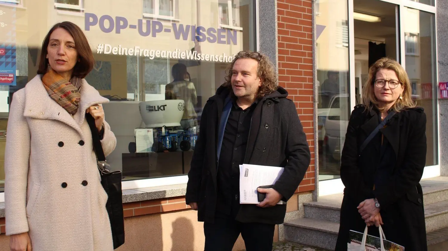 Prorektorin Prof. Roswitha Böhm (l.), Weißwassers Oberbürgermeister Torsten Pötzsch und Kulturbürgermeisterin von Dresden Annekatrin Klepsch vor dem neuen Pop-Up Wissensladen in Weißwasser.
