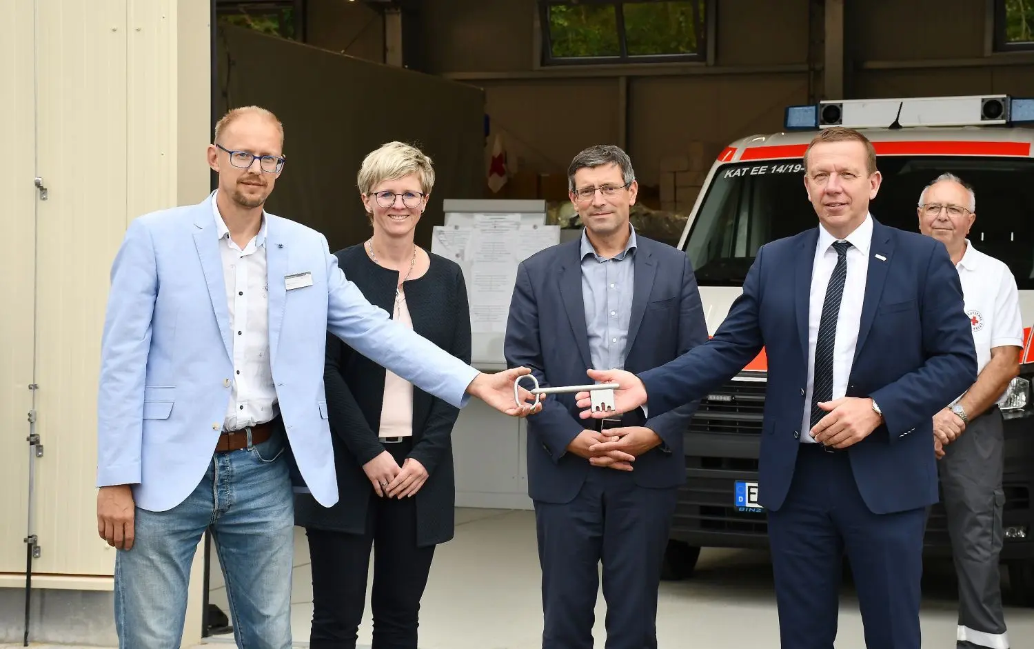 Ordnungsamtsleiter Marco Hanke nimmt im Beisein von Kathleen Wilken, Amtsdirektorin des Amtes Schradenland, und Innenstaatssekretär Uwe Schüler, den Schlüssel für das neue Katastrophenschutzobjekt in Gröden aus den Händen von Landrat Christian Heinrich-Jaschinski entgegen (v.l.n.r.).