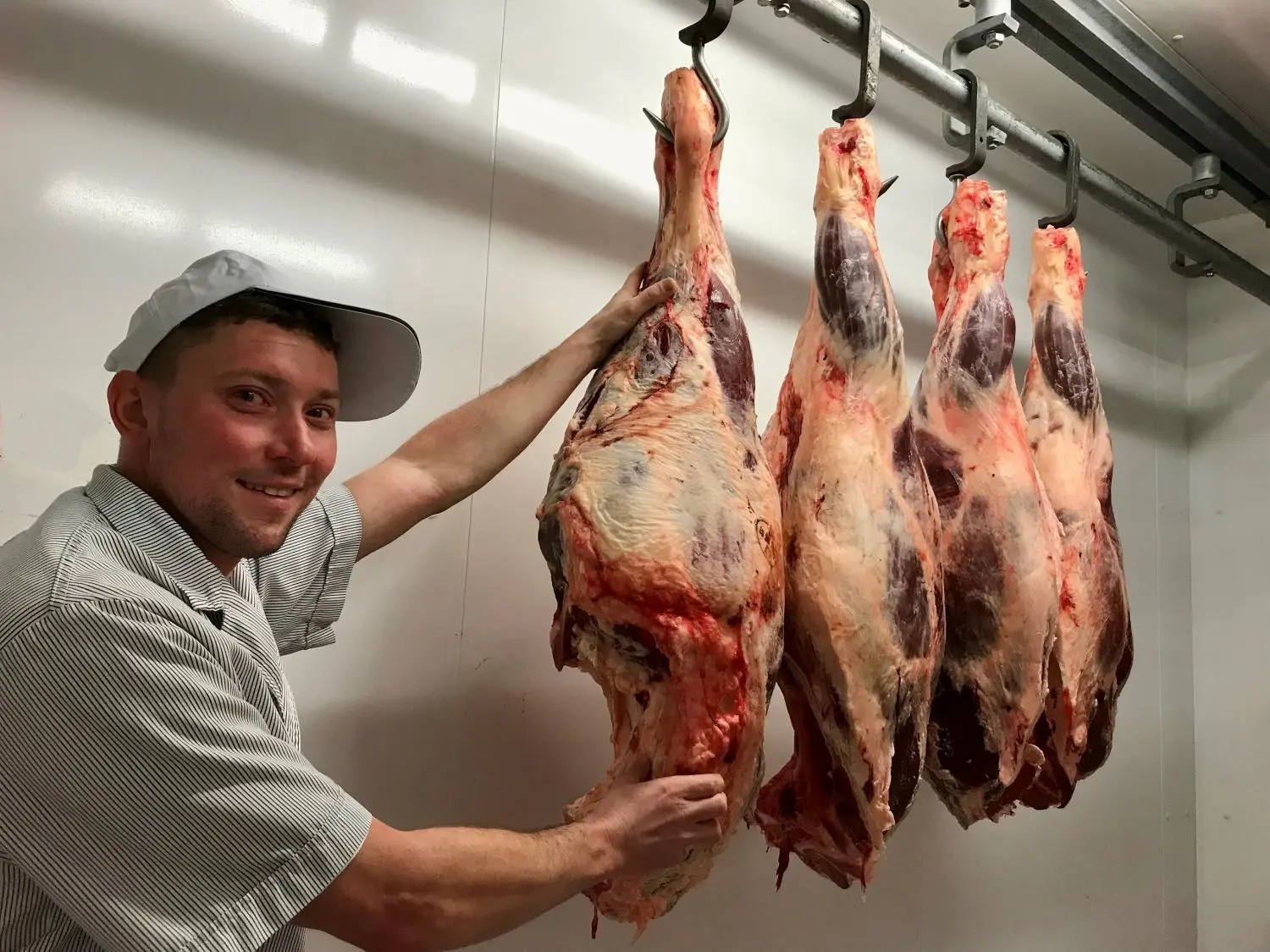 Roy Jochmann ist Fleischermeister und seit 2017 in der Viereichener Produktionsstätte beschäftigt. Er überprüft die Rinderkeulen in der Kühlkammer, die beim Hoffest in Neuliebel gegrillt werden.