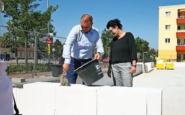 Sven Thamm mauert die zweite Zeitkapsel ein. Im Hintergrund ist die Seniorenresidenz zu sehen.