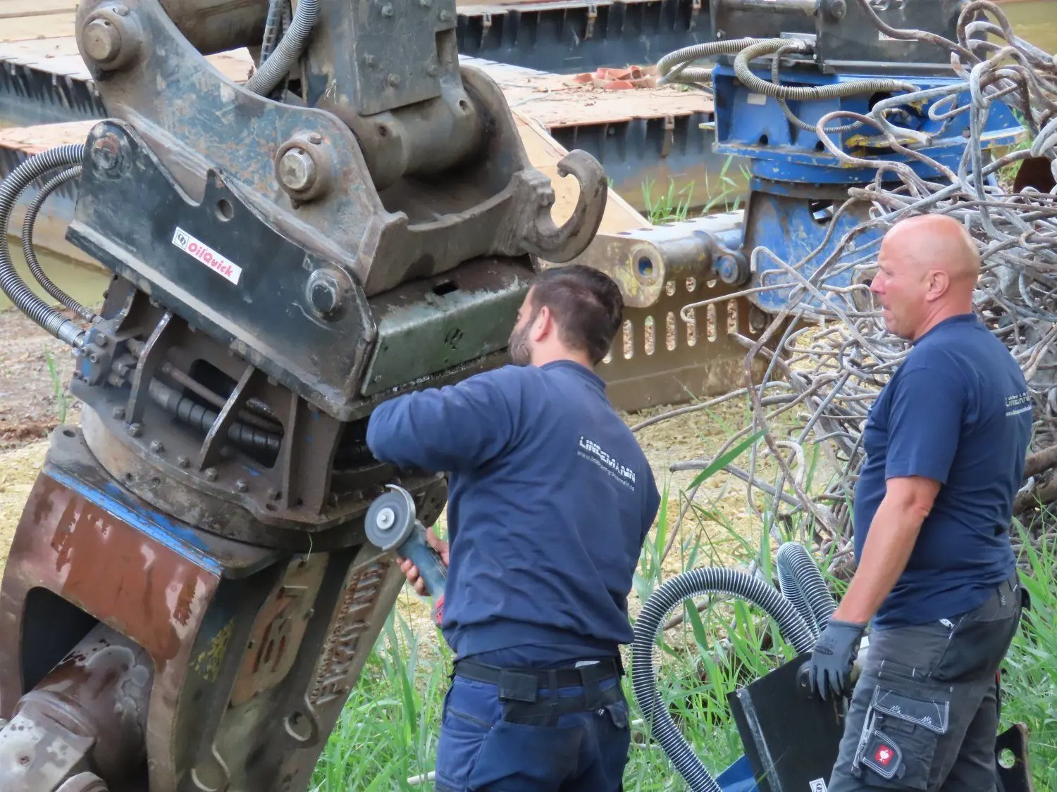 Martin Lindemann und der Baggerführer Enrico Karl (r.) warten die Hydraulik.