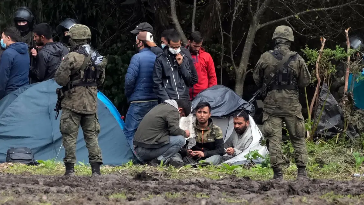 Polnische Sicherheitskräfte umringen Migranten, die an der Grenze zu Belarus festsitzen. Trotz dieser Maßnahmen an der EU-Außengrenze gelingt es vielen Menschen, sich weiter nach Deutschland zu bewegen.
ARCHIV - 01.09.2021, Polen, Usnarz Gorny: Polnische Sicherheitskräfte umringen Migranten, die an der Grenze zu Weißrussland festsitzen. Polen will den Ausnahmezustand an der EU-Außengrenze zu Belarus um 60 Tage verlängern. Grund dafür ist die illegale Einreise von Migranten aus dem Nachbarland. (Zu dpa «Migranten an Grenze zu Belarus: Polen will Ausnahmezustand verlängern») Foto: Czarek Sokolowski/AP/dpa +++ dpa-Bildfunk +++