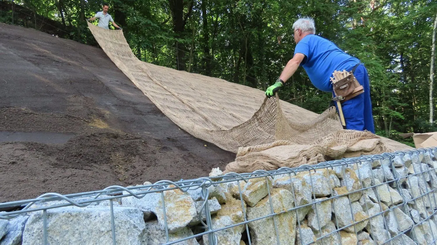Böschungsmatten aus Jute legen René Klein (l.) und Tim Körnig aus. Sie sind von der City Forest GmbH, einem Garten- und Landschaftsbauunternehmen aus Radeburg bei Meißen, nach Spremberg gekommen.