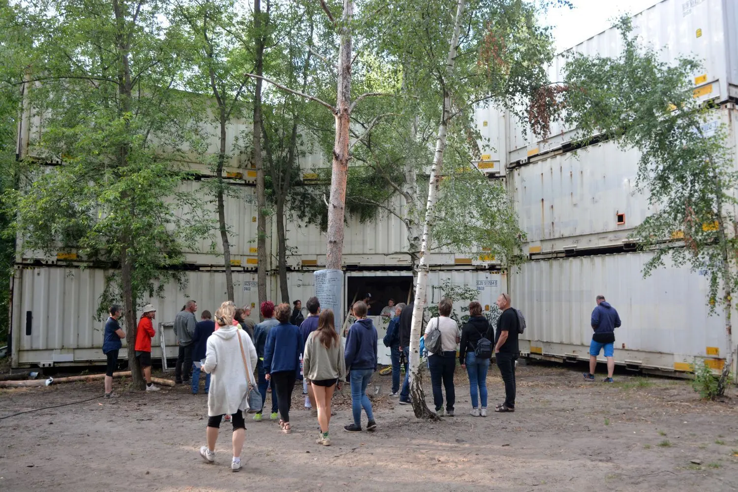 Übereinandergestapelte Industrie-Container sollen zu noch mehr Lärmschutz beitragen. Aus einem freigeschnittenen Fenster im unteren Mittel-Container werden Festivalbesucher unterhalten. Die Performance-Area trägt den Namen „Puppenräuber“.
