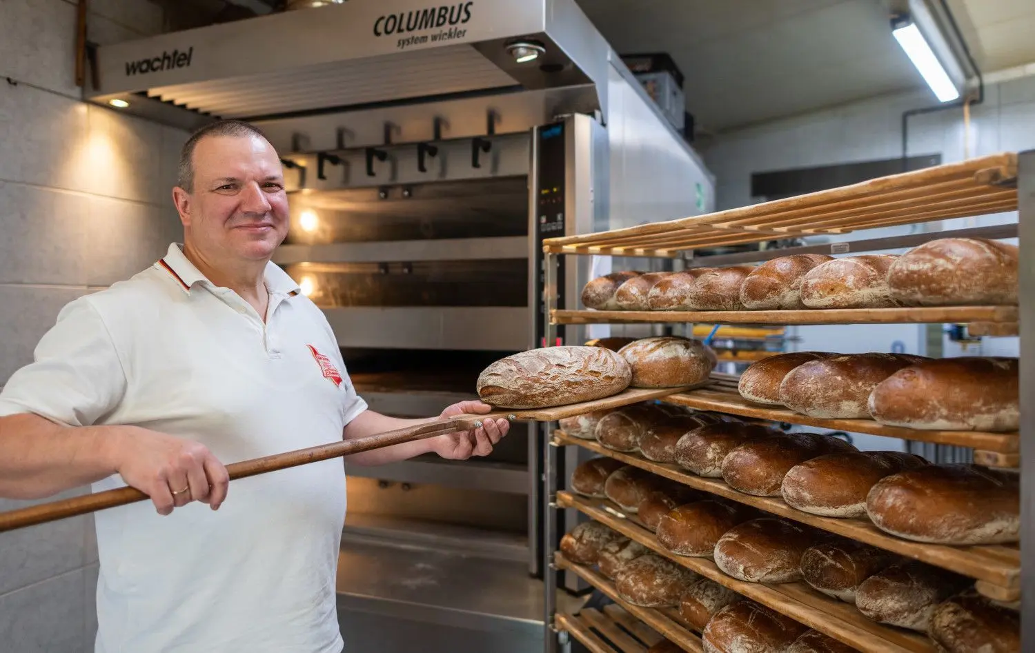 Roland Ermer, Bäckermeister und Präsident des Sächsischen Handwerkstages, steht mit einem Brotschieber in seiner Bernsdorfer Backstube.