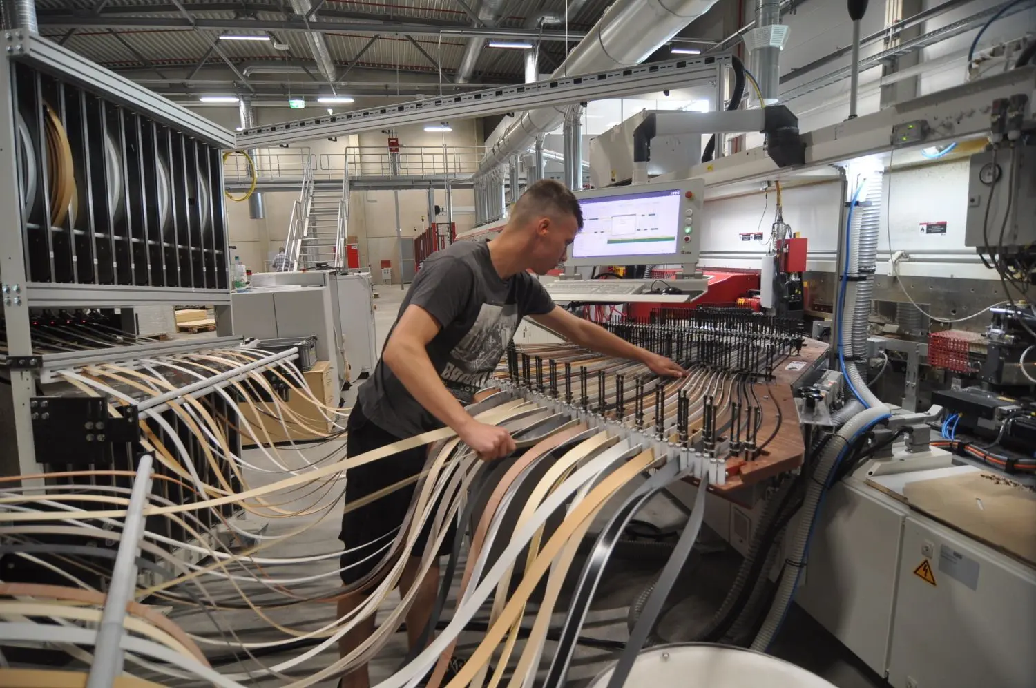 Elias Gattermann an der Kantenbeschichtungsanlage. Der 20-Jährige hat in der Reiss Büromöbel GmbH in Bad Liebenwerda eine dreieinhalbjährige Ausbildung zum Industriemechaniker absolviert, ist übernommen und sofort an der computergesteuerten Maschine eingesetzt worden.