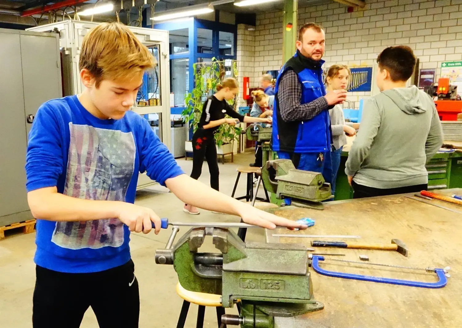 Max Ludwig arbeitet konzentriert an seinem Metallwürfel. Mit der Pfeile rundet er die Ecken ab.