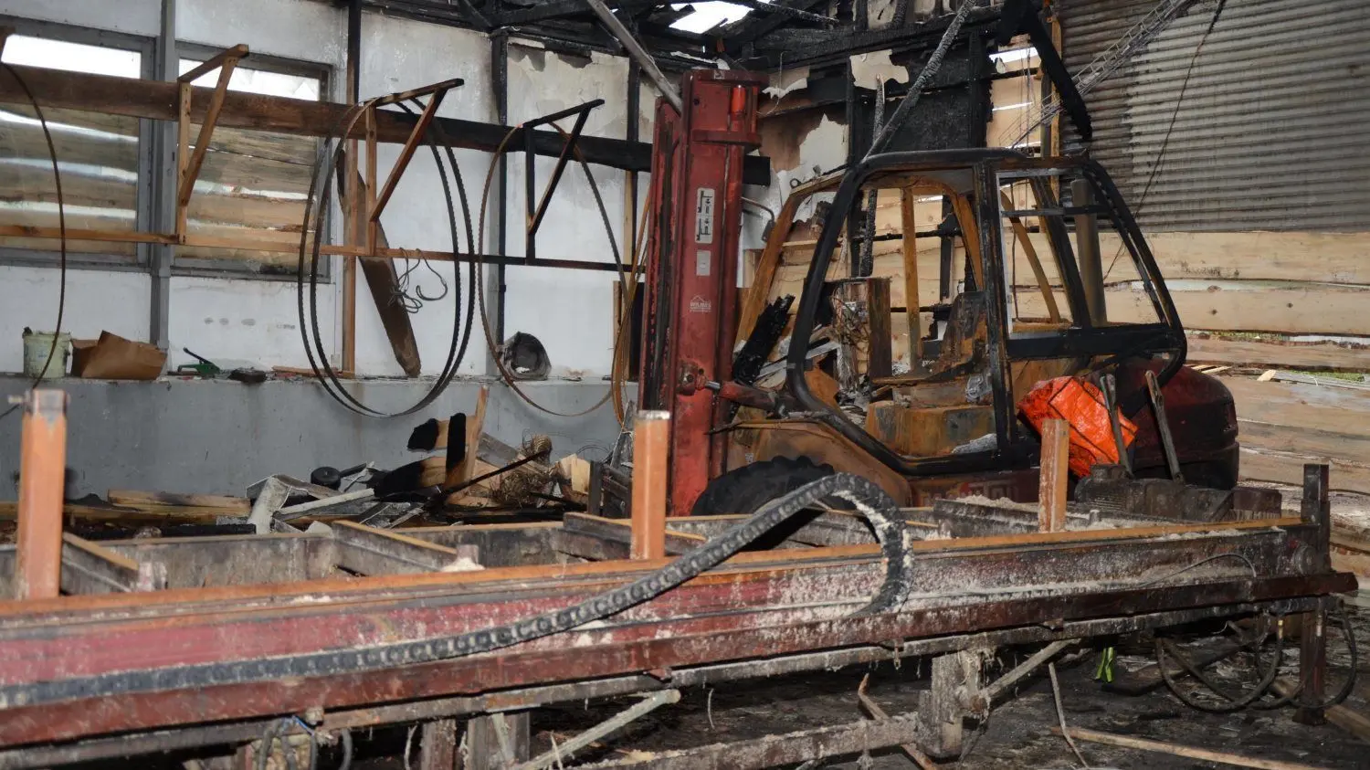 Brandherd im Sägewerk in Lübbenau mit völlig ausgebranntem Gabelstapler. Die Blockbandsäge (im Vorgergrund) ist möglicherweise noch funktionstüchtig.