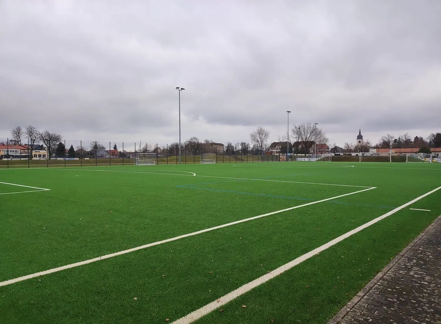 In Lübbenau findet ein Weihnachtsgottesdienst auf dem Kunstrasenplatz des Spreewaldstadions statt. Eine der örtlichen Kirchen ist dabei sogar im Sichtfeld.