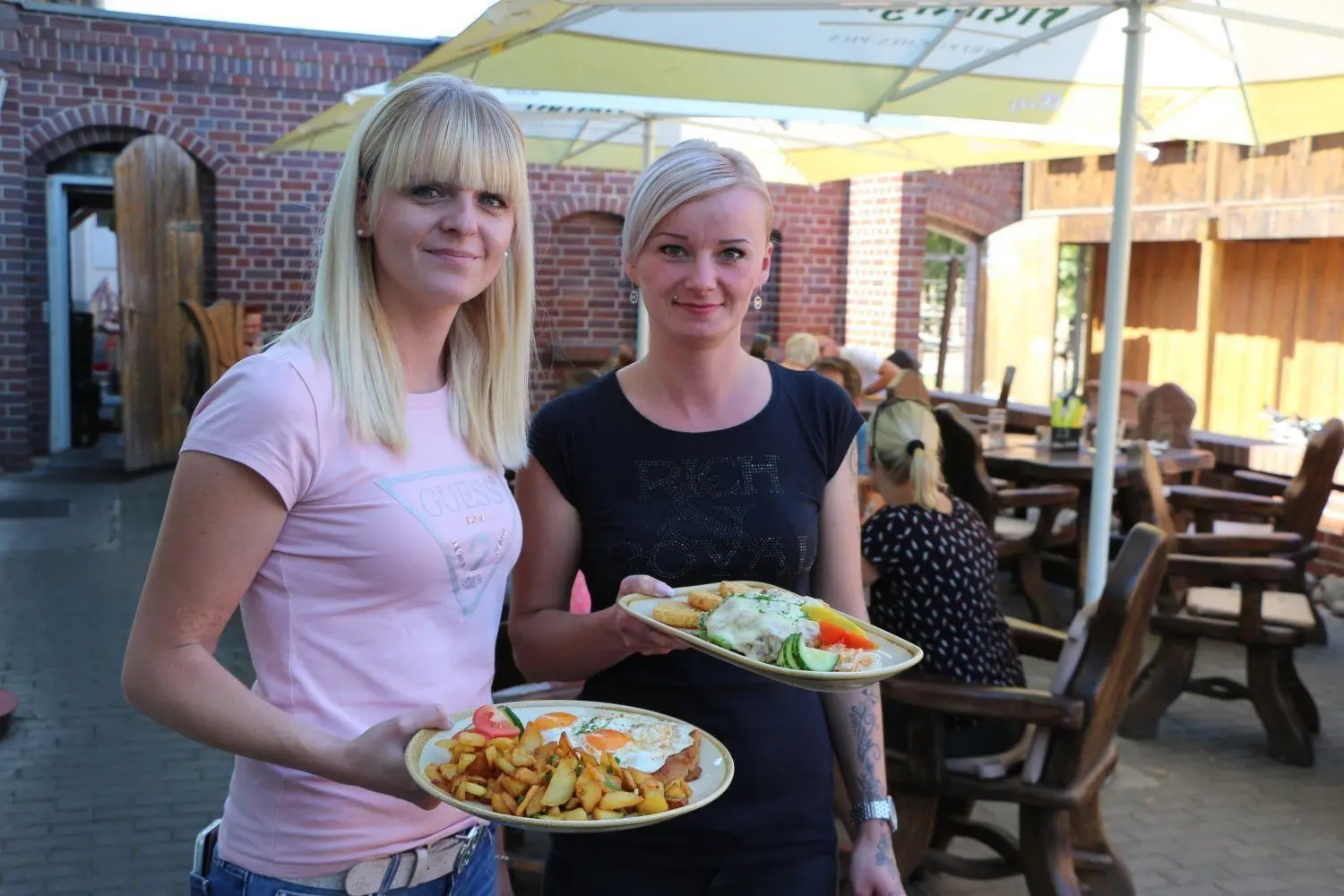 Stefanie Schäfer (29, li.), Marketing-Chefin vom Partwitzer Hof, trägt mit Kellerin Renata Becker (32) das Essen raus.