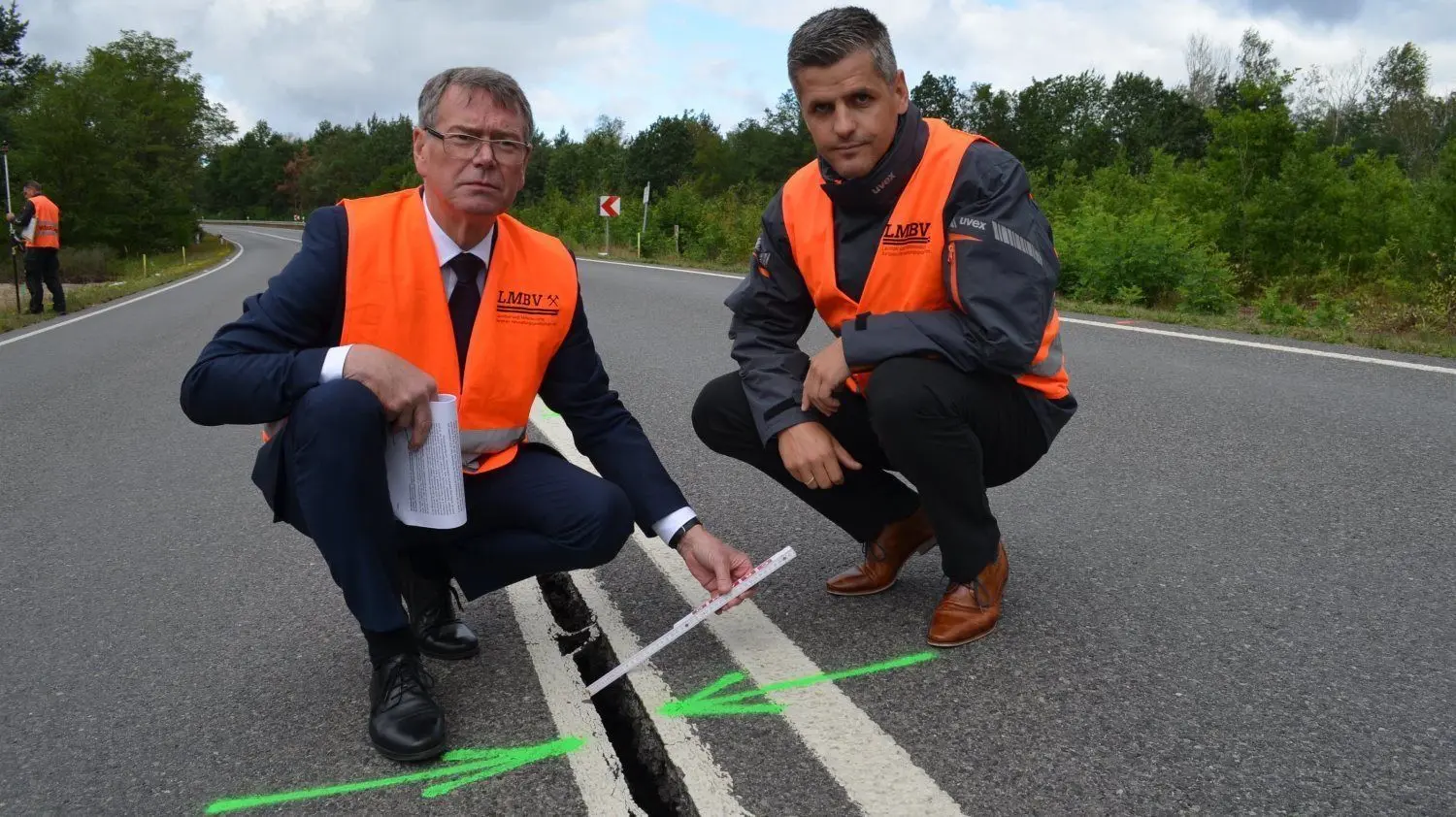 LMBV-Sanierungsbereichsleiter Gerd Richter (l.) und Abteilungsleiter Karsten Handro zeigen die schlimmste Stelle: Dort hat sich die Straße um mehrere Zentimeter gesenkt. Mitten auf der B 97 tut sich die Straße auf.