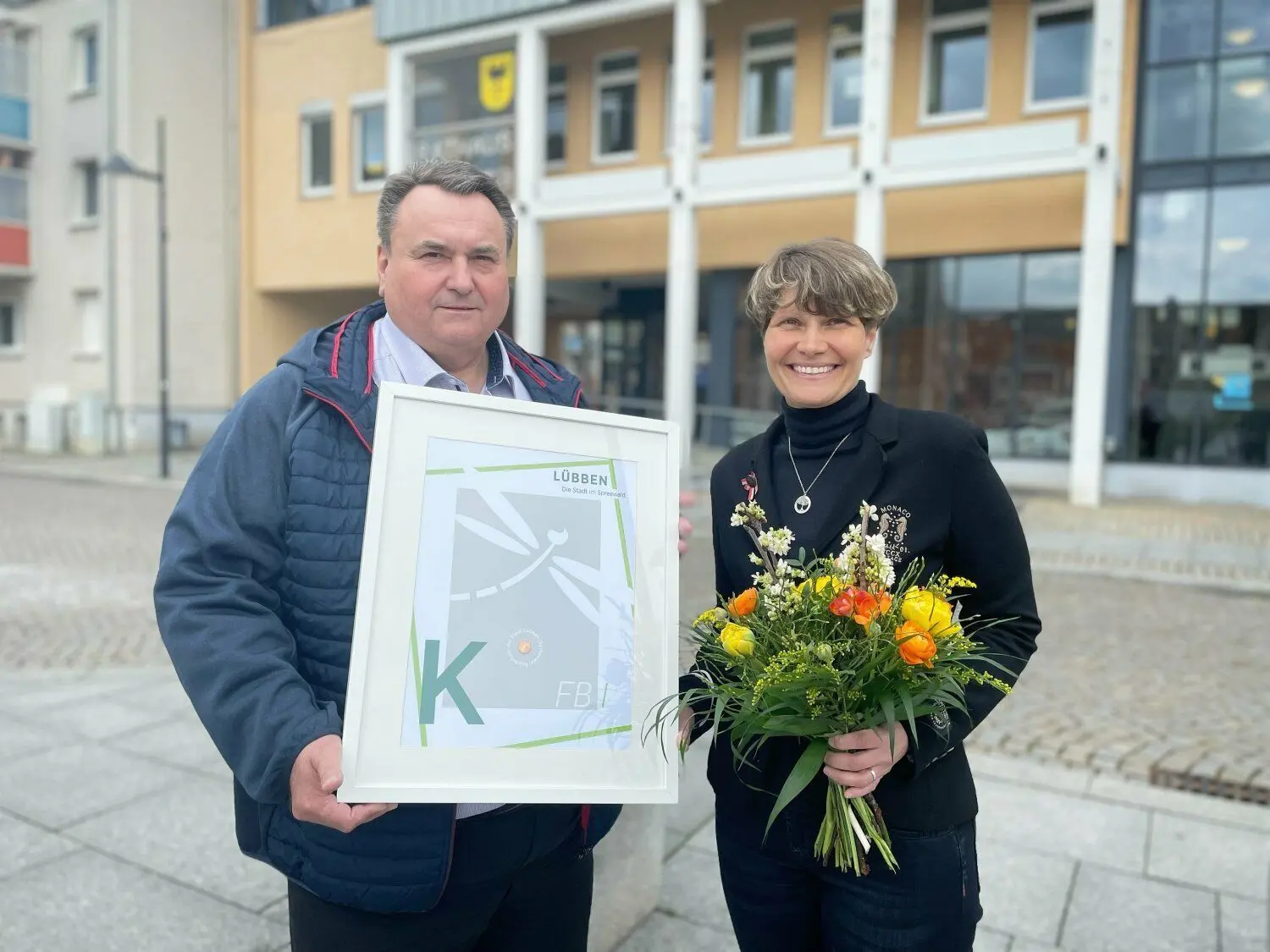 Der stellvertretende Bürgermeister Frank Neumann begrüßt Melanie Brückner auf dem Lübbener Marktplatz. Noch am selben Tag kündigt sie.