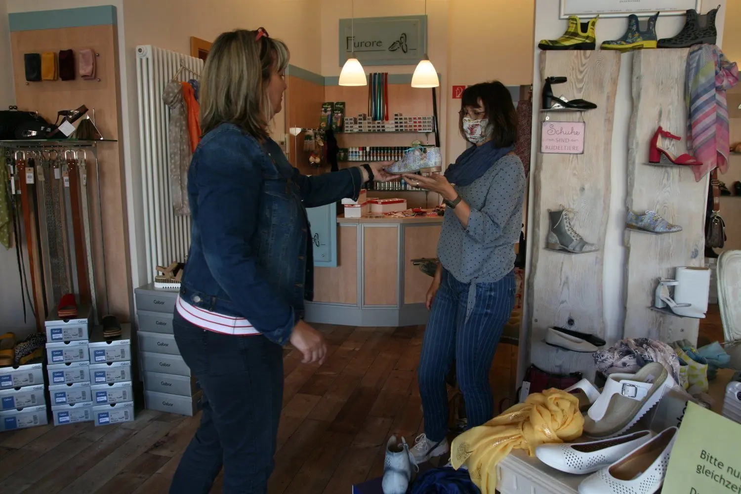 Zum Schutz ihrer Kunden trägt Kathrin Schulz (r.)  im Schuhhaus Furore in Lübben eine Maske.