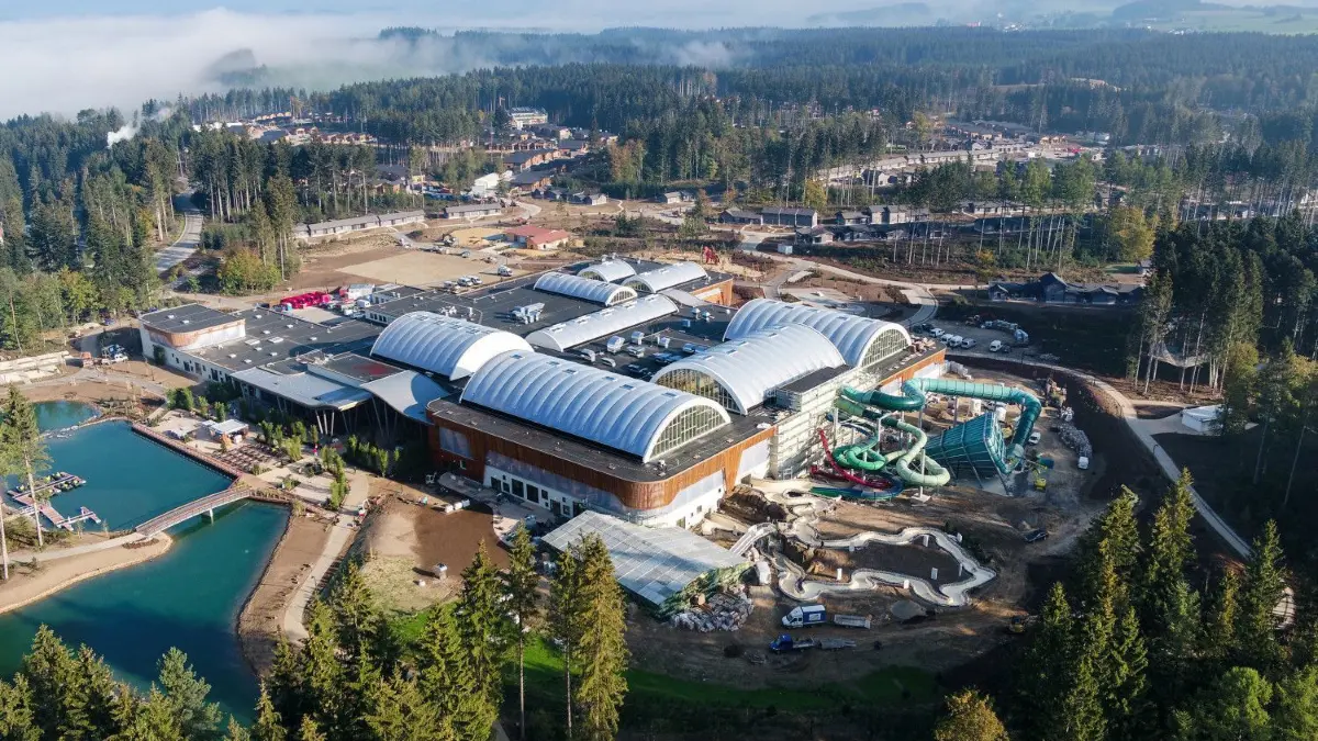 Center Parcs Allgäu: Um das Zentralgebäude mit tropischem Bad, Gastronomie und Geschäften sind Ferienhäuser und Freizeitangebote gruppiert.
ARCHIV - 30.09.2018, Baden-Württemberg, Leutkirch In Allgäu: Nebel liegt hinter dem neuen Center Parcs Allgäu. Bei einem Unfall auf einer Wasserrutsche in der Center-Parcs-Ferienanlag sind zwei Erwachsene und zwei Kinder verletzt worden. (Aufnahme mit einer Drohne - zu dpa "Vier Verletzte nach Unfall auf Wasserrutsche") Foto: Felix Kästle/dpa +++ dpa-Bildfunk +++