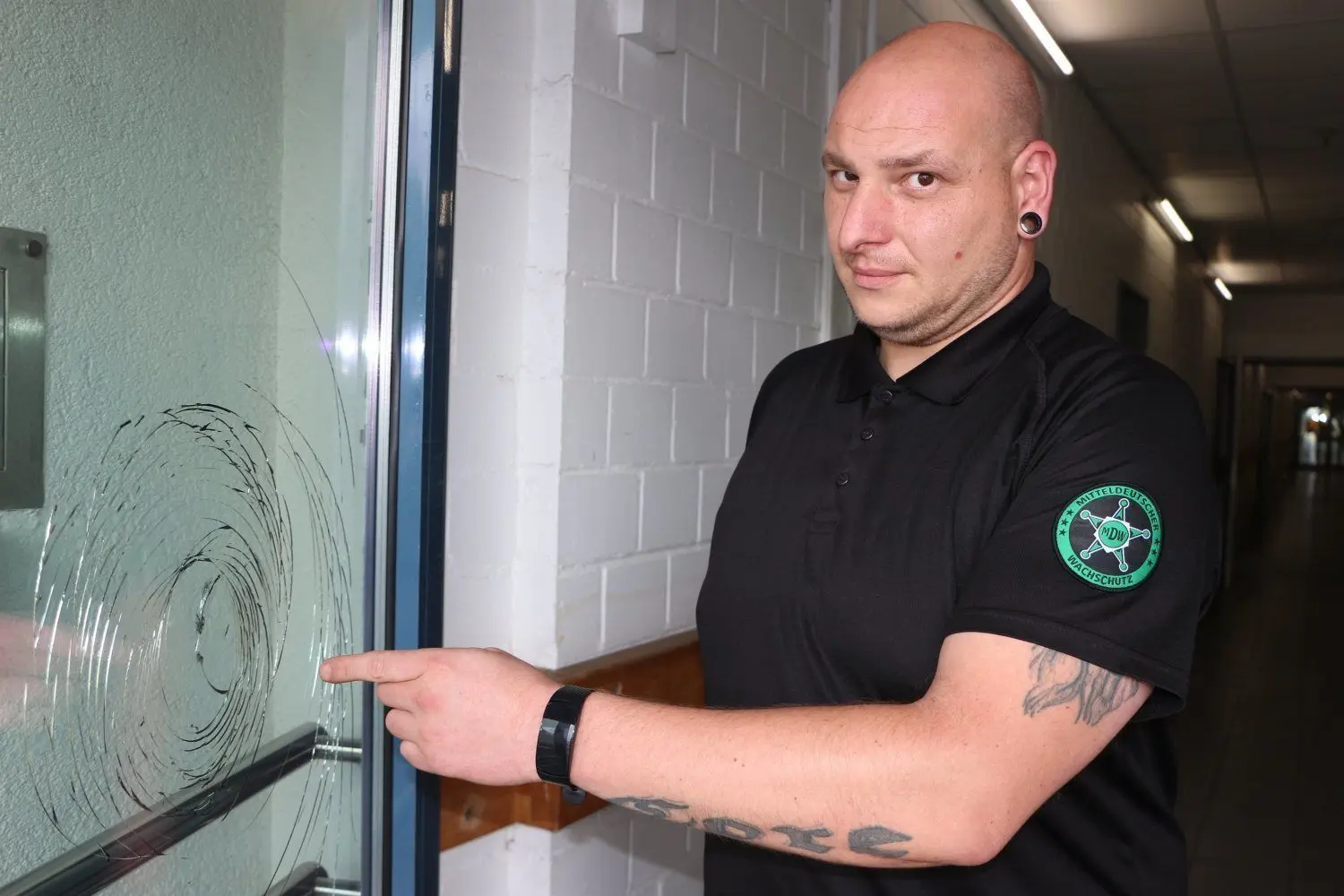 Renüe Mickel (38), Wachmann vom Mitteldeutschen Wachschutz in Hoyersewrdas Lausitz-Center, zeigt im Bereich der Warenannahme auf eine zerstörte Scheibe.