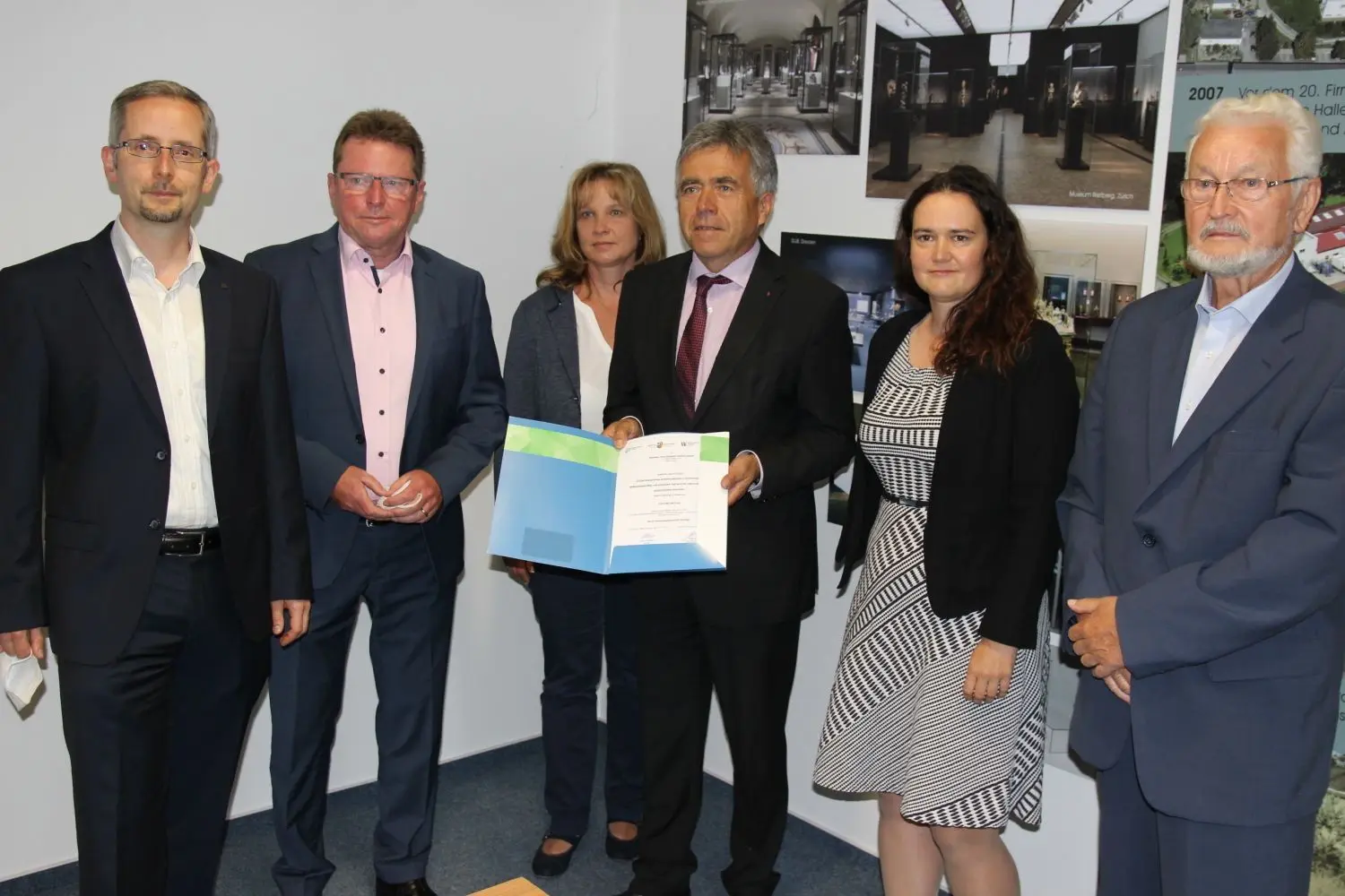 Landrat Michael Harig (M.) präsentiert hier den Förderbescheid über gut 124 000 Euro für die Reier GmbH. Mit dem Geld soll ein neuer Vitrinenkleber entwickelt werden. Mit von der Partie sind der Lautaer Bürgermeister Frank Lehmann, Heiko Jahn von der Wirtschaftsregion Lausitz, Anja Linke als Protagonistin des Modellvorhabens „Unternehmen Revier“, Reier-Prokuristin Christiane Düffort sowie Firmengründer Volker Reier (v.l.).