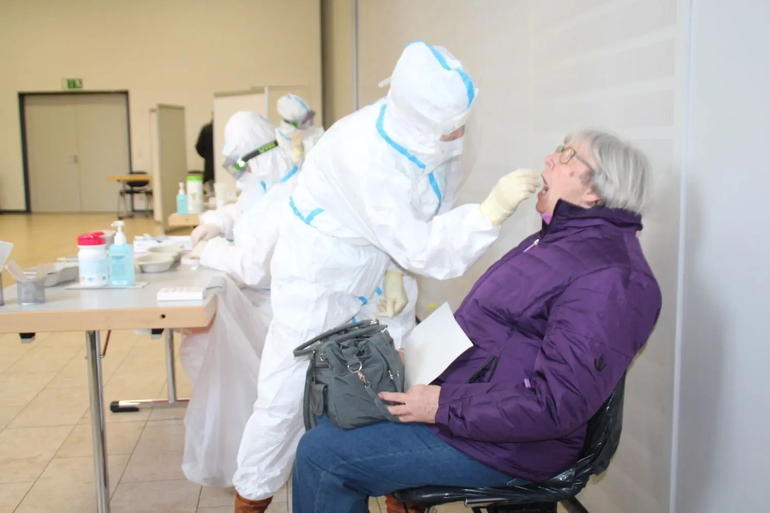 Im Testzentrum in Hoyerswerda nimmt diese 72-Jährige am Corona-Massentest des Landkreises Bautzen teil. Eine Mitarbeiterin des Gesundheitsamtes nimmt mit einem Wattestäbchen einen Rachenabstrich.