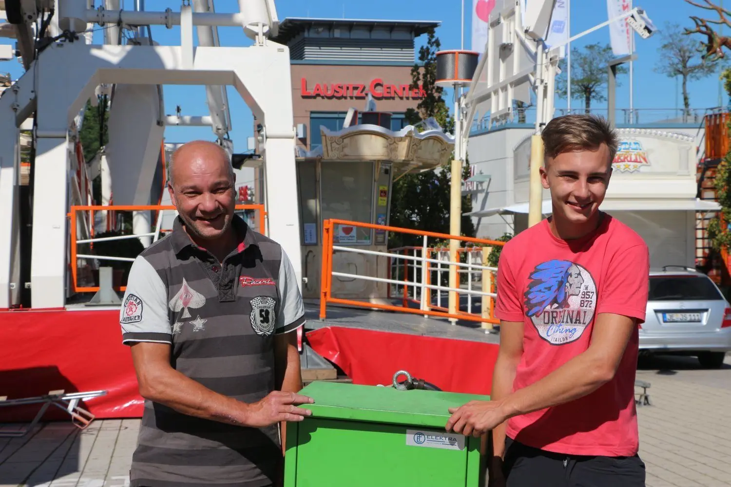 Vater und Sohn Tino und Danielo Sperlich aus Jessen schleppen den Generator für die Eismaschinen. Auf dem Rummel vorm Lausitz-Center betreiben sie am kommenden Wochenende eine Bar.