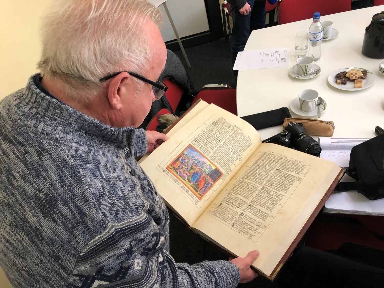 Der geistliche Seelsorger Hans-Joachim Grothe hält die gestohlene Bibel aus der Kreuzkirche in Hoyerswerda wieder in den Händen. Die Heilige Schrift wurde in der Wohnung des Diebes beschlagnahmt. Foto: Hummel