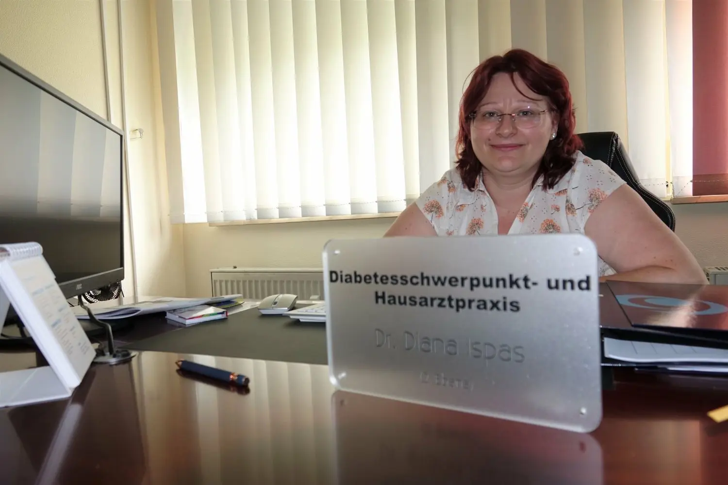 Dr. Diana Ispas an ihrem Schreibtisch in der neuen Praxis in Weißwasser. Das Schild, das auf ihre Praxis hinweist, ist mittlerweile am Eingang angebracht.