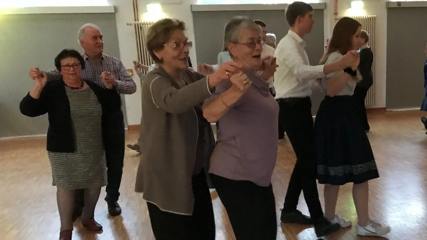 Ingrid Mühl (80) und Isolde Pohl (76, dritte und vierte von links) stürmen zur Annemarie-Polka, dem Auftaktlied zum Tanzcafé im Niedersorbischen Gymnasium auf die Bühne.