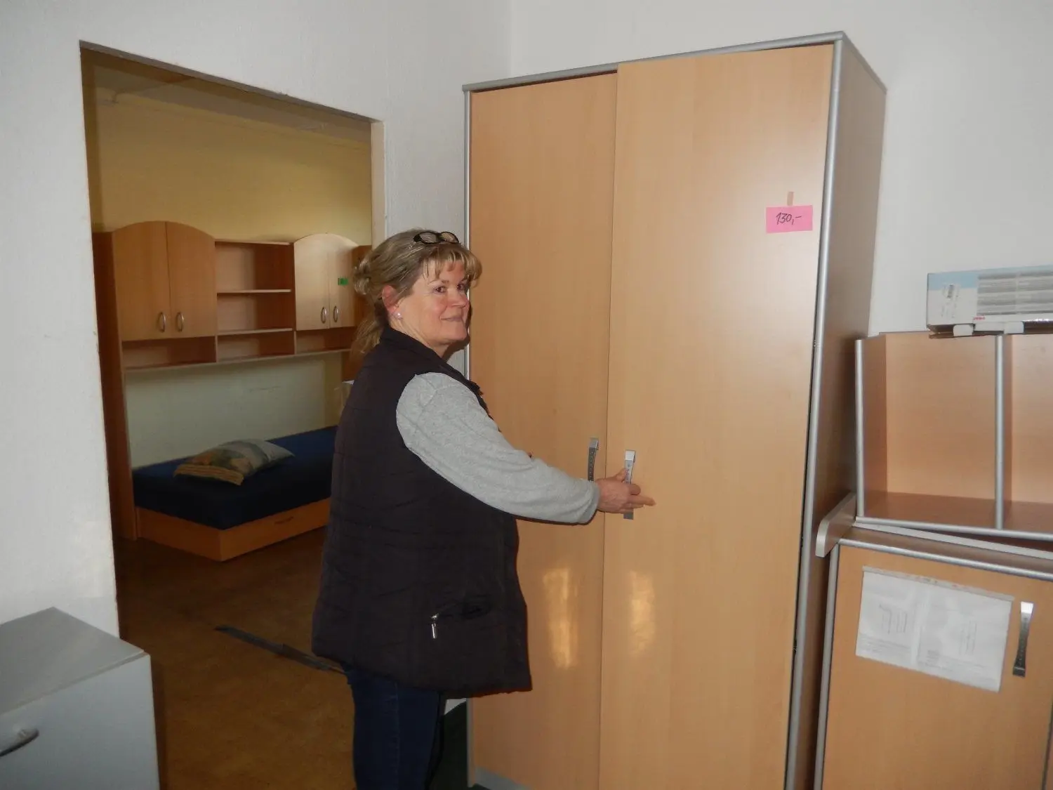 Petra Ebel, Leiterin der Möbelbörse in Groß Schacksdorf, präsentiert einen Schrank.