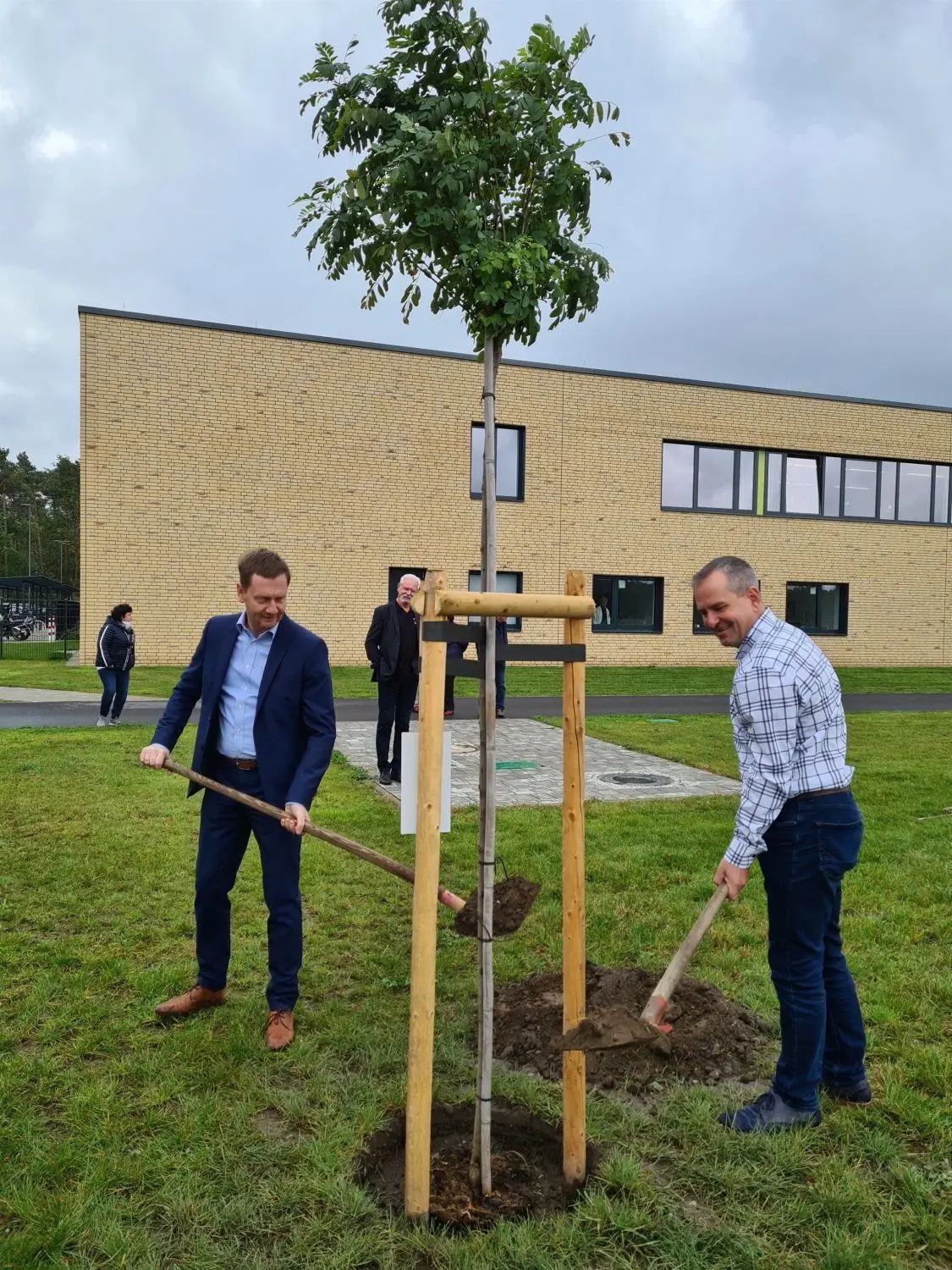 Der Schulkomplex ist um eine Robinie reicher. Ministerpräsident Michael Kretschmer und Amtsverweser Jörg Funda versorgten den Baum des Jahres 2020 noch mit einigen Schaufeln bester Muttererde. Die Vorarbeit hatte Gärtner Daniel Struck übernommen.
