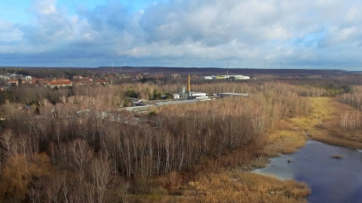 Blick auf die Bergbaufolgelandschaft der Grube Lauchhammer III, die 1921 ausgekohlt war. Der Naundorfer Teich (unten) ist ein Restloch des Alttagebaus. Das Gewerbegebiet an der Wilhelm-KülzStraße (Bildmitte) und vier unmittelbar an der Straßenzufahrt gelegene Häuser stehen auf gefährlichem Grund. Die benachbarten Einfamilienhäuser und die weiter nördlich errichteten Wohnblöcke im Friedenseck sind indes sicher auf gewachsenem Boden gebaut. ⇥
Foto: Mirko Sattler/ Blick über die Grube Lauchhammer III (1898–1921) bei Lauchhammer. Der Naundorfer Teich (unten) ist ein Überbleibsel des Alttagebau. Das Gewerbegebiet Wilhelm Külz Strasse ( Bild Mitte). Weiter nördlich die Wohnblöcke des Friendenseck