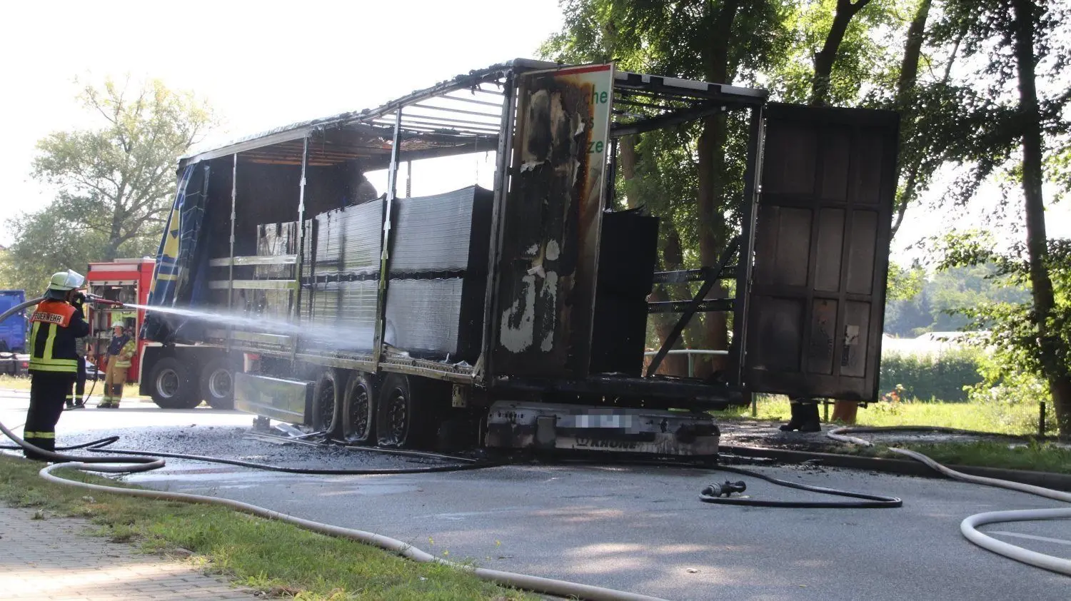 Die Feuerwehr löscht den Brand an einem Lkw-Auflieger in der Berliner Straße in Kolkwitz.