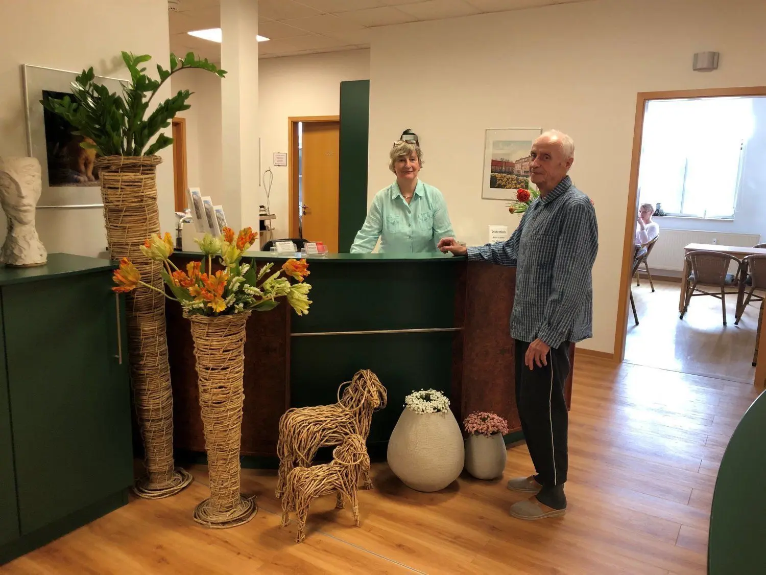 Das Cottbuser Stadthospiz ist auch in Zeiten der Pandemie österlich geschmückt. Schwester Ines freut sich gemeinsam mit einem Hospizbewohner an dem fröhlichen Blumenschmuck.