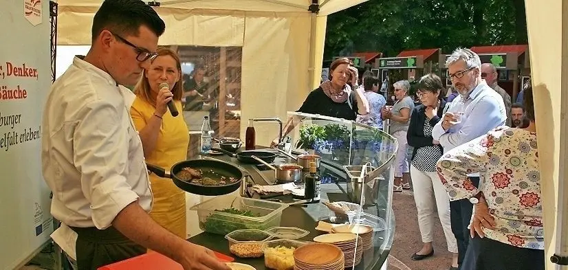 Am Stand des mobilen pro agro Kochstudios: Stefan Täubert, einst Koch bei Donald Trump, kocht seit drei Jahren für die Bäckerei Bubner. Am Sonntag durfte seine neueste Leckerei verkostet werden, die auch bei Bubners in Finsterwalde ab sofort auf dem Menüplan steht: Spinat-Ricotta-Knödel auf Tomatensauce mit Rucola, Parmesan und Pinienkernen.