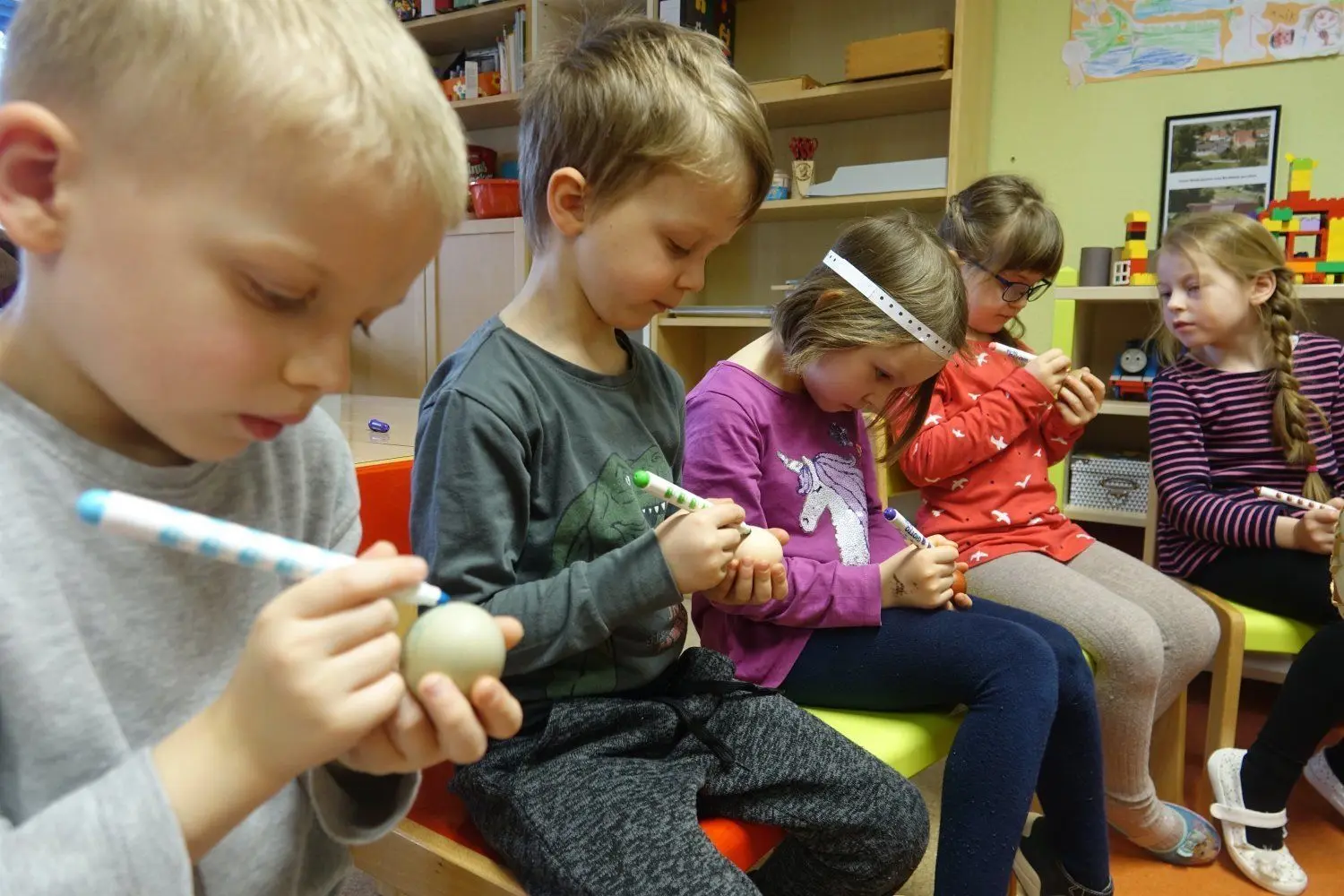 Aron, Malte, Merea und Johanna sind ganz bei der Sache, um "ihren" Eiern ein Erkennungsmal auf die Schale zu malen.