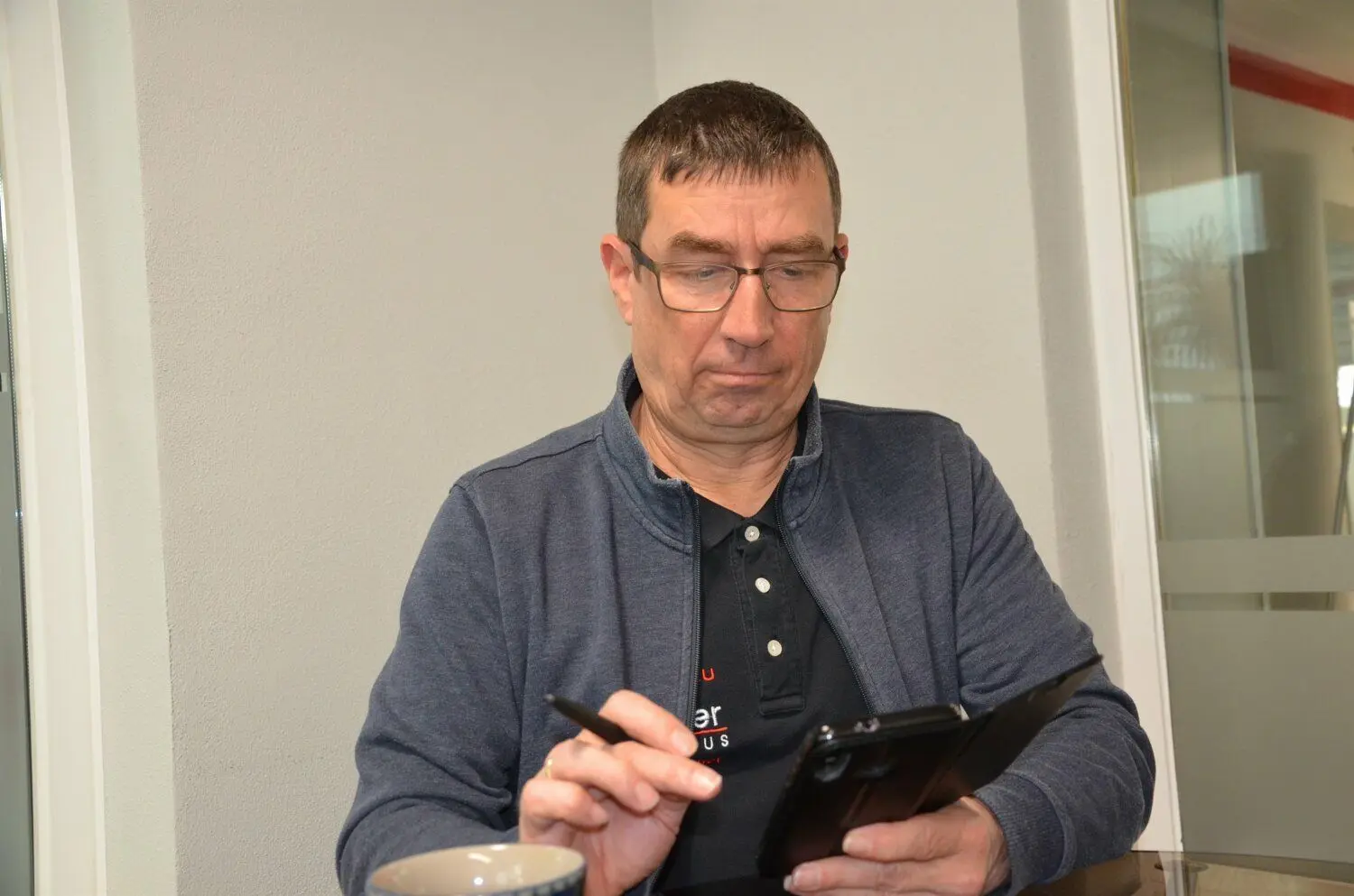 Dirk Fischer, Vorsitzender des ESV Lok Guben, begutachtet die Bilder vom Schaden.
