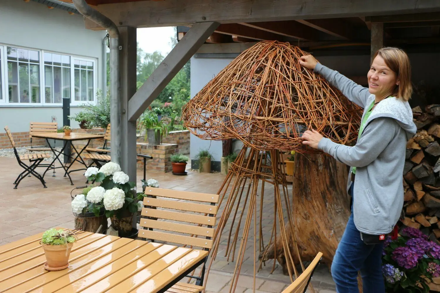 Kreativ bei Wind und Wetter: Seenlandhof-Mitarbeiterin Kornelia Winter kümmert sich um die Dekoration. Für die Terrasse des neuen Hof-Cafés hat die Floristin einen riesigen Pilz aus Weidenzweigen geflochten.