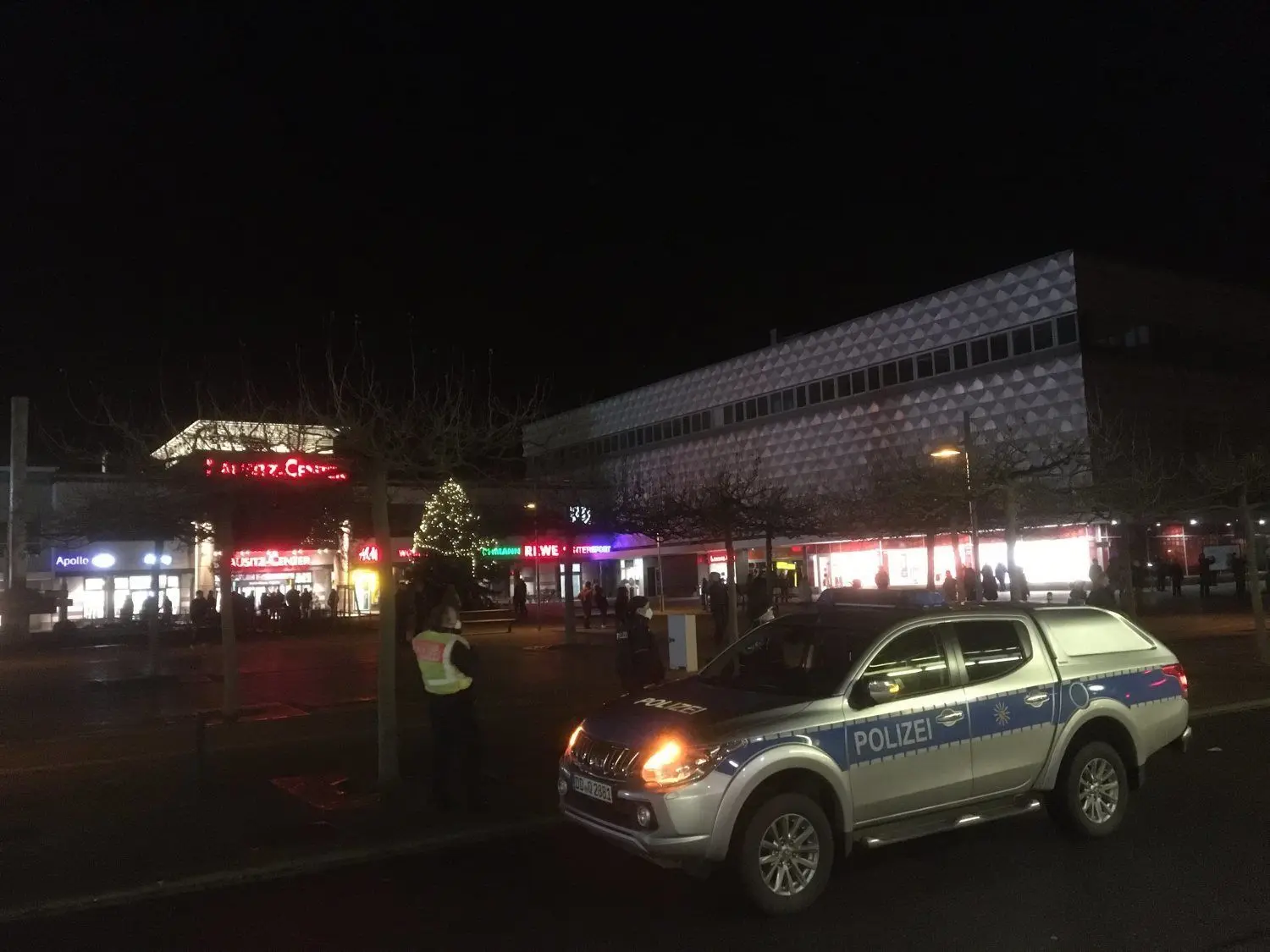 Hoyerswerda: Teilnehmer des Corona-Spaziergangs haben sich in kleinen Grüppchen auf dem Lausitzer Platz versammelt. Die Polizei überwacht die Situation.