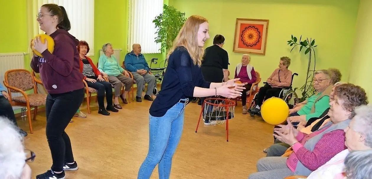 Die Elftklässlerin Laura Hirthe (Mitte) wirft einer Bewohnerin des evangelischen Seniorenzentrums in Lübben einen Ball zu. ⇥
