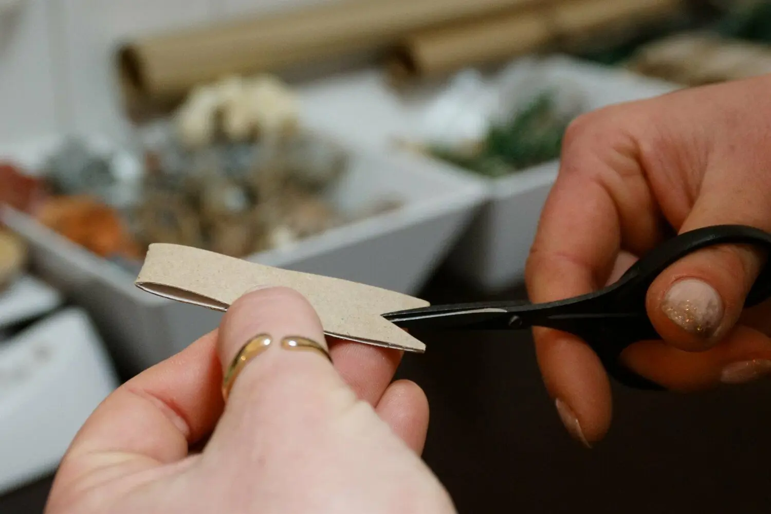 Mit einer Nagelschere werden dann bei allen drei Streifen jeweils an beiden Enden kleine Dreiecke ausgeschnitten. Dabei darf die Schere nicht direkt in den Ecken angesetzt werden, dort muss etwas Pappe übrig bleiben.