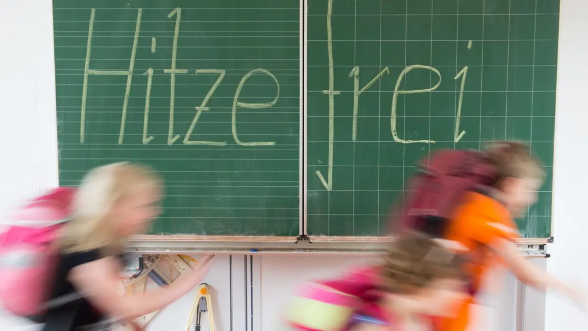 Nichts wie raus aus dem heißen Klassenzimmer: An einigen Crailsheimer Schulen gibt es Hitzefrei, an anderen muss weiter unterrichtet werden, egal wie hoch die Temperatur ist. Eine einheitliche Regelung gibt es nicht. ⇥
ARCHIV - 30.06.2015, Sachsen, Dresden: ILLUSTRATION - Schüler einer 2. Klasse laufen in einer Grundschule an einer Tafel mit der Aufschrift "Hitzefrei" vorbei. (zu dpa vom 23.06.2019) Foto: Sebastian Kahnert/dpa-Zentralbild/dpa +++ dpa-Bildfunk +++