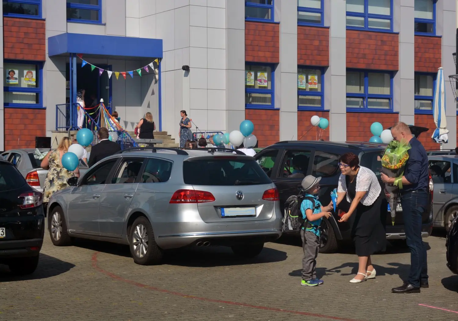 Erstklässler Erik Kockro nimmt in Großräschen die Glückwünsche von Mutter Anja Neumann entgegen. Vater Maik wartet schon mit der Zuckertüte für den Abc-Schützen der Familie.